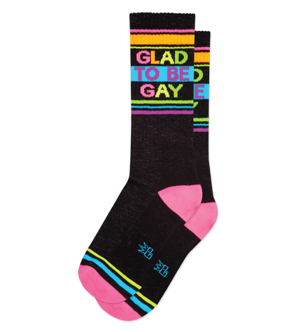 Glad to be gay crew socks in black cotton with vibrant rainbow stripes and bold colorful phrase on top