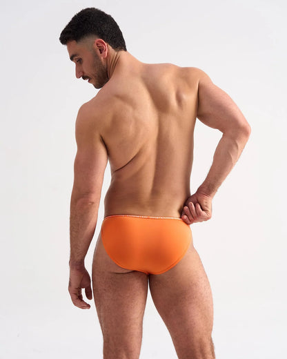 Bright orange glide micro brief with subtle white trim along the waistband designed for comfortable support
