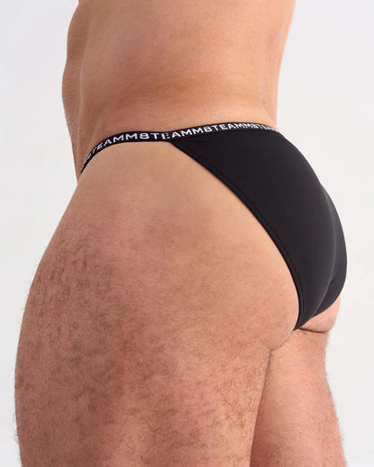 Black glide micro brief with a repeating white logo waistband band designed for comfort and support