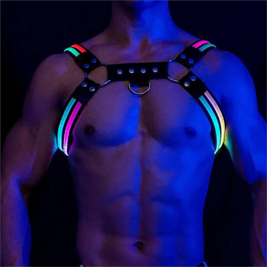 Black leather harness with glowing pink and blue light strips, metal rings, and studs against a dark background.