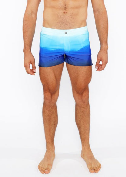 Gradient printed swim shorts with blue ombre pattern and white waistband designed for swimming and beachwear