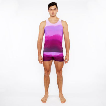 A man wearing a gradient printed swim short and matching tie-dye tank top in purple and pink colors
