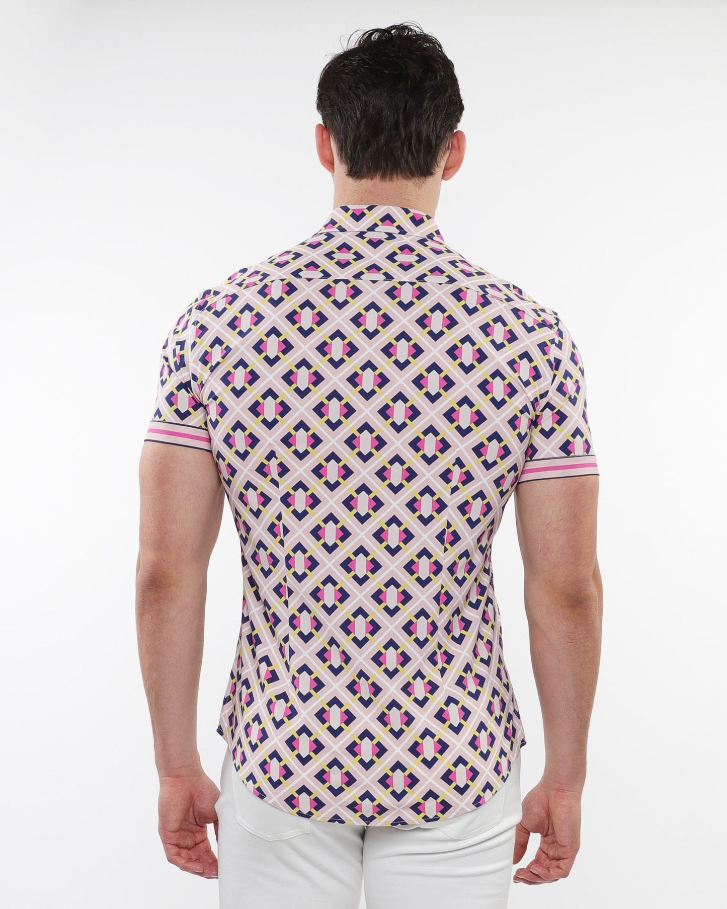 A man wearing a pink purple and cream grid parquet printed performance short sleeve button up shirt on a light background