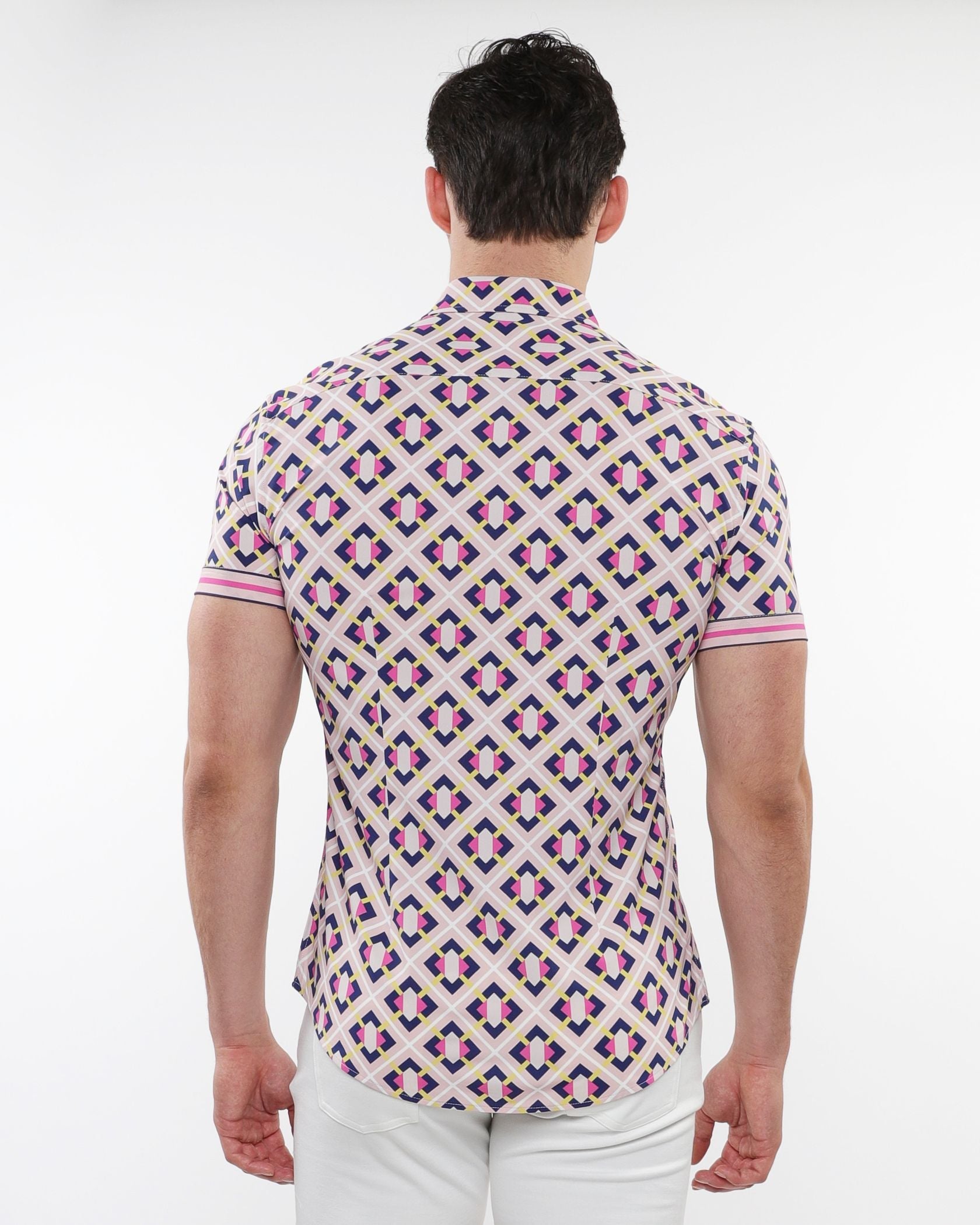 A man wearing a pink purple and cream grid parquet printed performance short sleeve button up shirt on a light background
