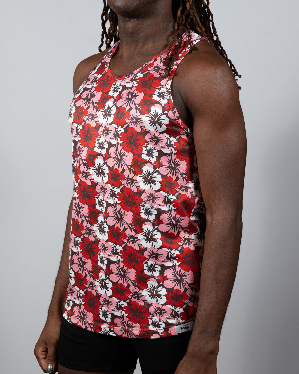 A vibrant red pink and white hawaiian hibiscus print tank top with a racerback design perfect for summer wear