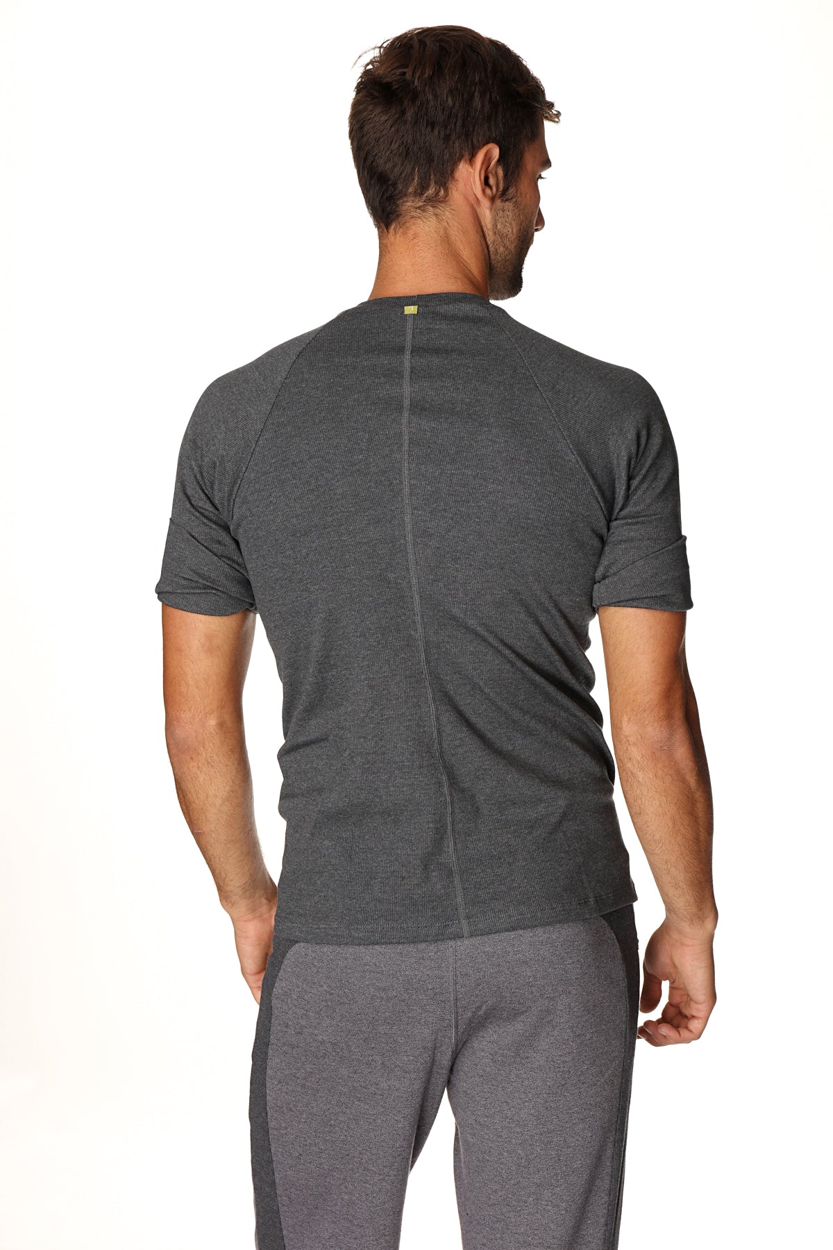 Back view of a dark gray heathered hybrid crew neck raglan tee with a subtle vertical seam for athletic wear