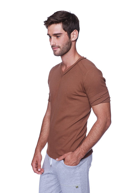 A man wearing a hybrid v neck chocolate brown short-sleeved t shirt made from soft breathable fabric