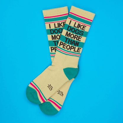 Cream-colored crew socks with teal and pink stripes featuring black text i like dogs more than people for casual wear