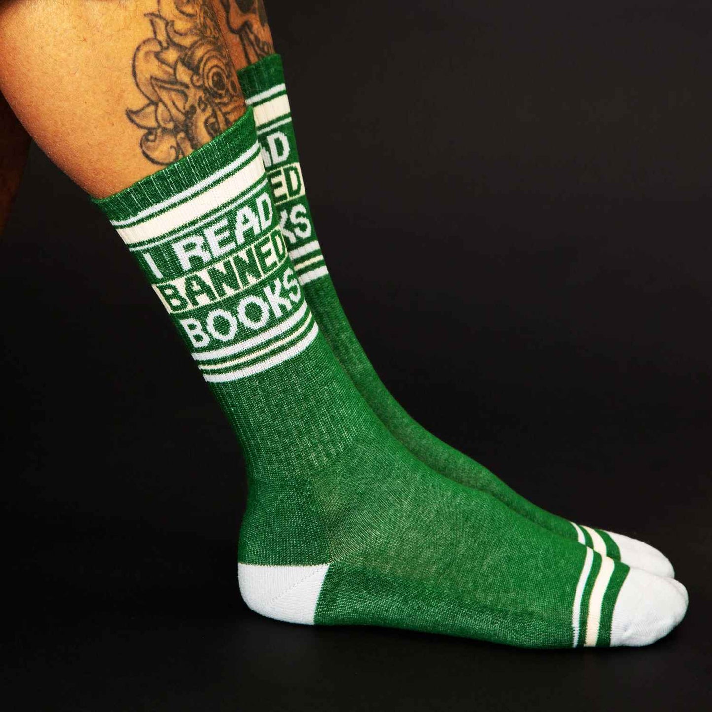 Green crew socks with white stripes and bold i read banned books text made of textured knit material