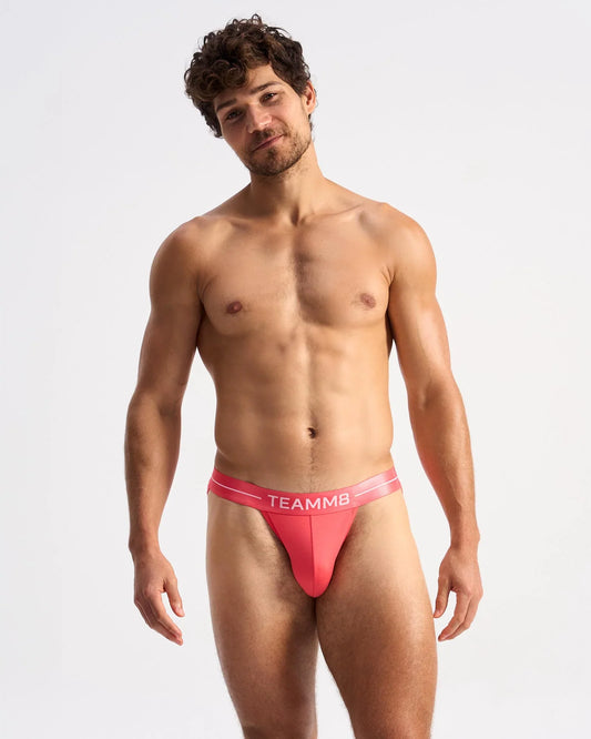 Vibrant coral-colored teammb icon sports brief with sleek form-fitting design for activewear and athletic use