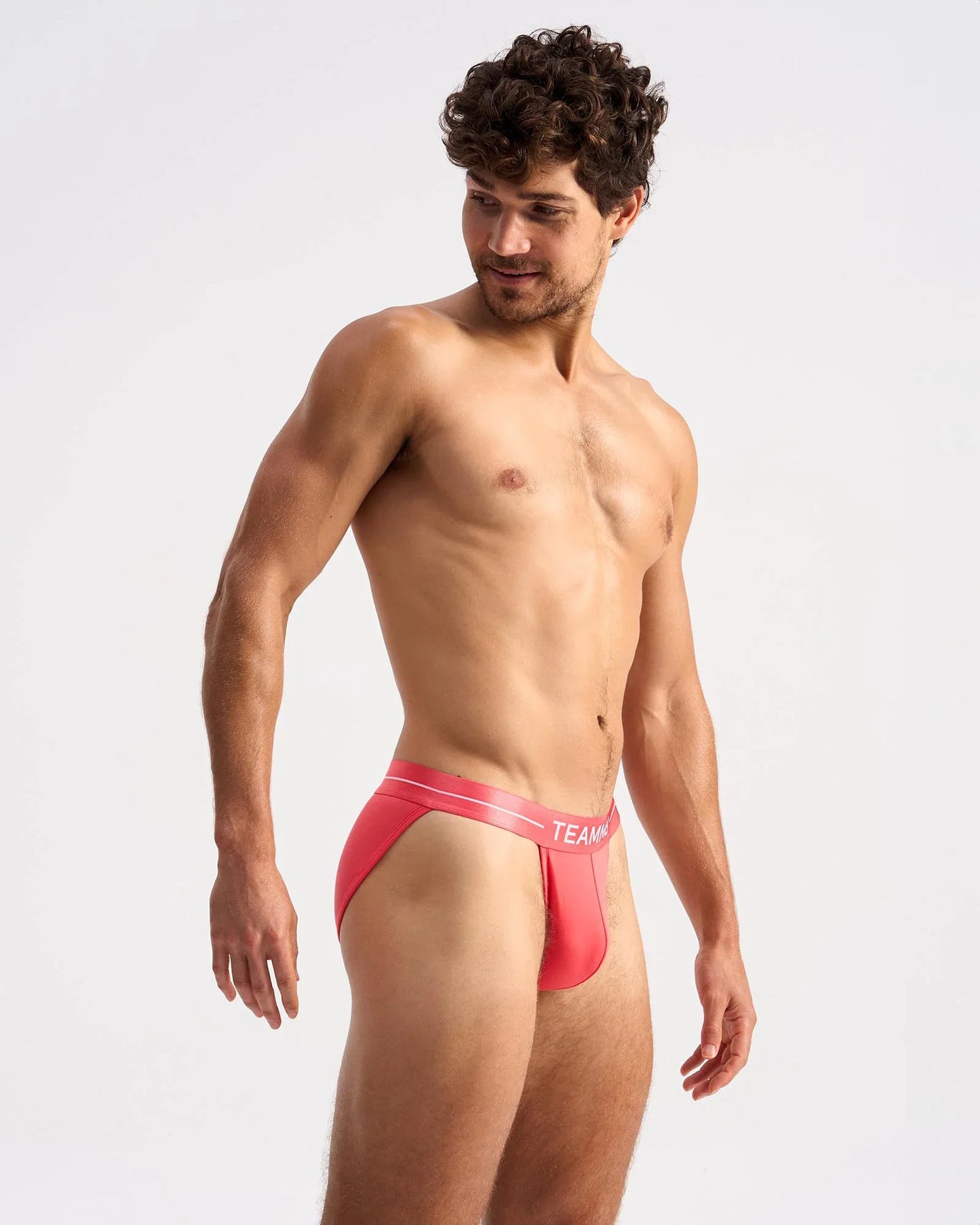 Bright coral-red icon sports brief with white elastic waistband featuring team logo in form-fitting design