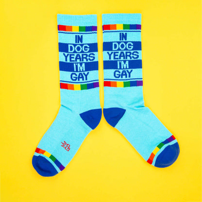 Light blue crew socks with navy text in dog years im gay rainbow stripes and dark blue toe caps