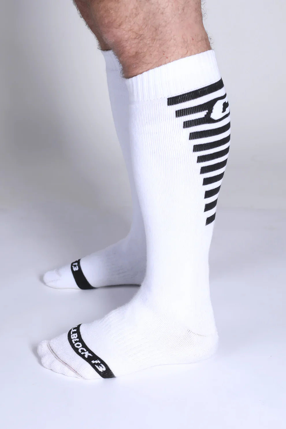 White athletic knee high socks with black diagonal stripes and tiblock 13 branding on the side iron grip knee high sock