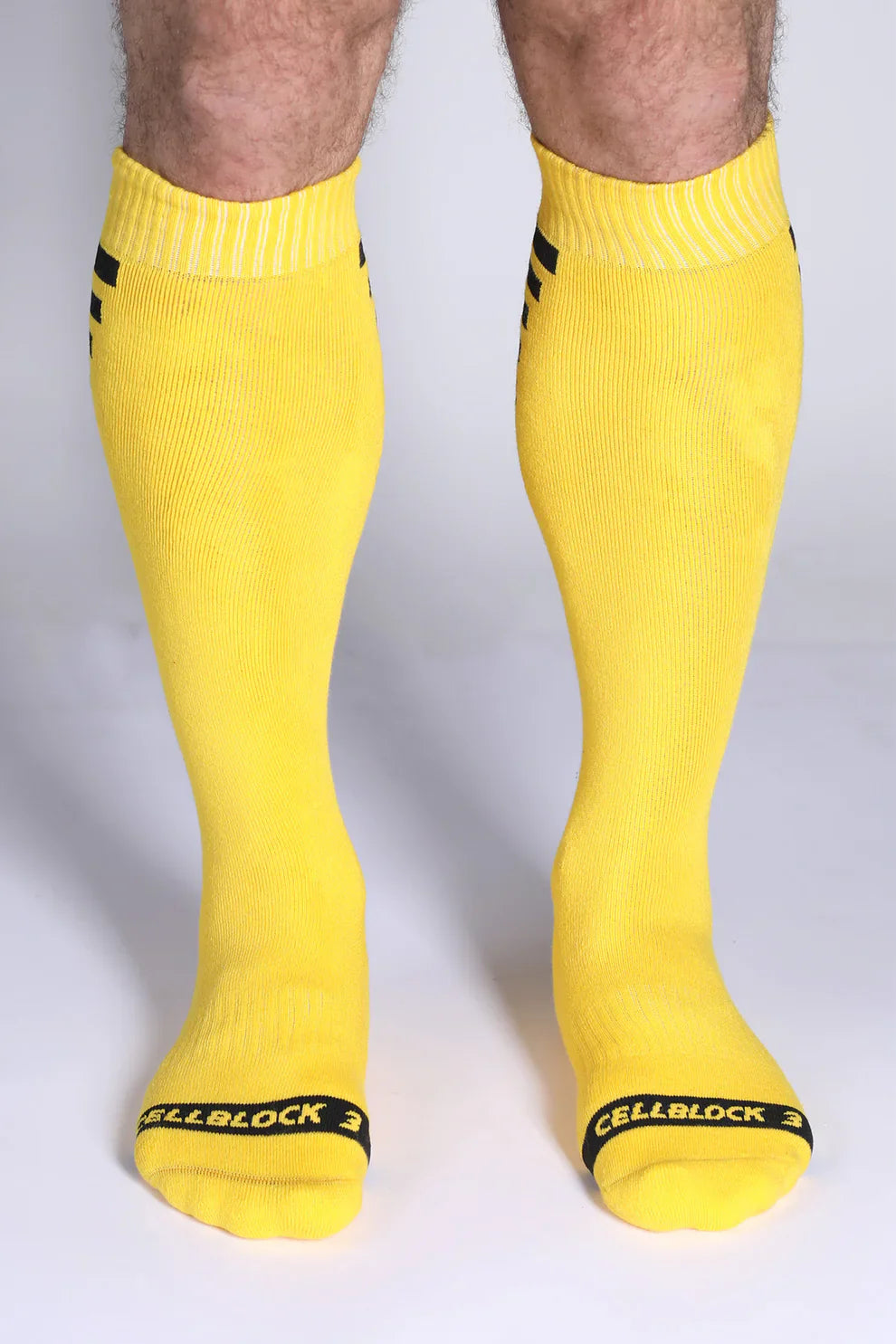 Iron grip knee high socks in bright yellow with black stripes on cuff and cellblock 3 branding at the toe