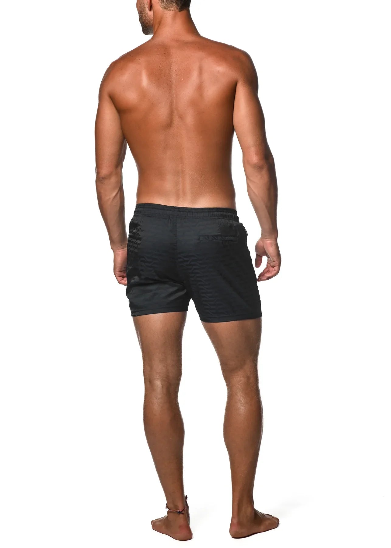 Black jacquard stretch swim shorts with textured ribbed fabric and subtle logo on the back pocket view