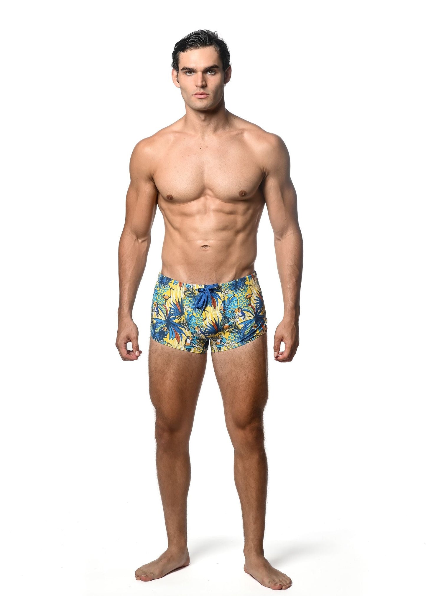 Jungle printed swim trunk featuring men’s tropical leaf pattern in vibrant yellow and blue for beachwear