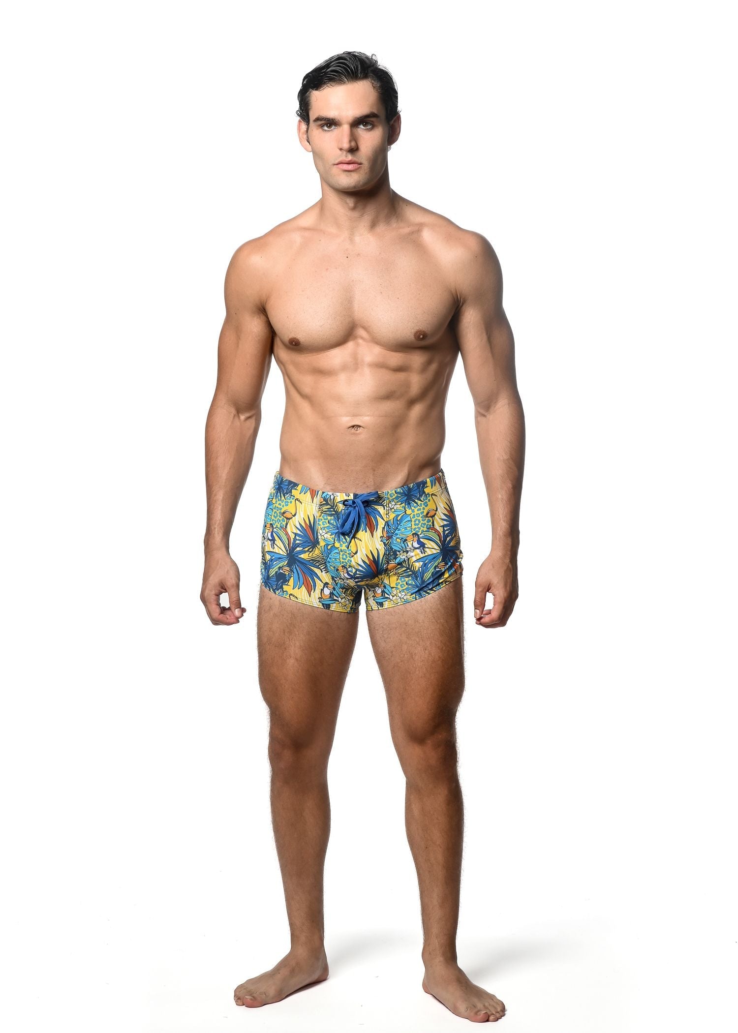 Jungle printed swim trunk featuring men’s tropical leaf pattern in vibrant yellow and blue for beachwear