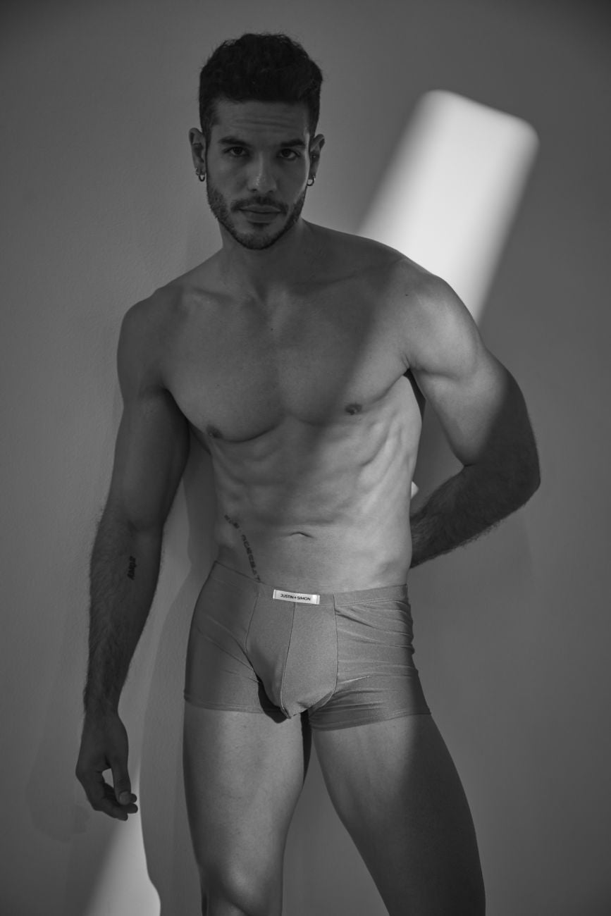 A man wearing light-colored form-fitting calvin klein classic boxer briefs with a metal green waistband label