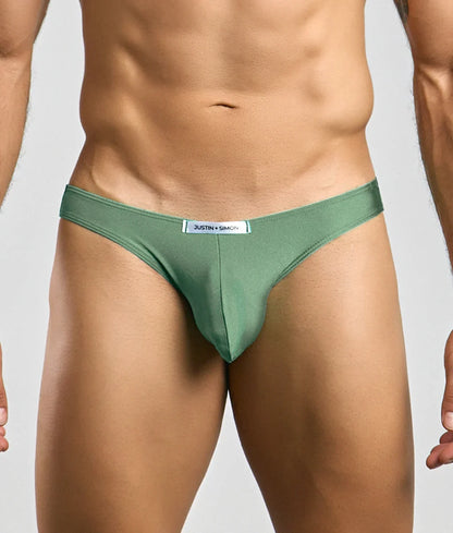 A sleek olive green smooth fabric thong with subtle sheen and branded label at the waistband from Justin Simon classic mens bikini
