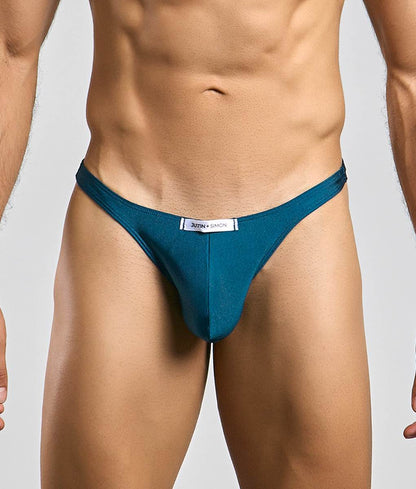 Teal-colored justin + simon classic tanga thong with a sleek form-fitting design shown from the front
