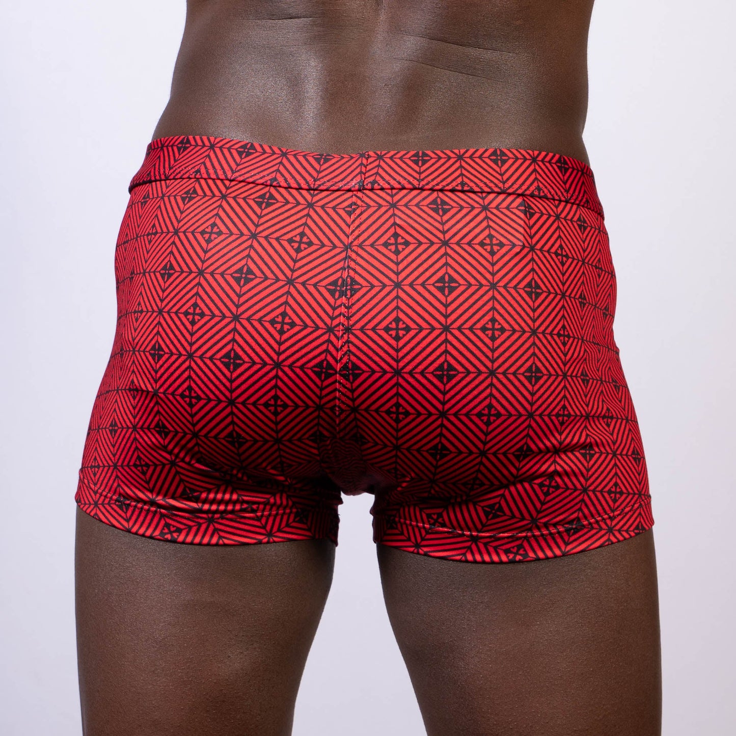 Red kaleidoscope sq cut swim trunks with black geometric pattern designed for swim and beachwear