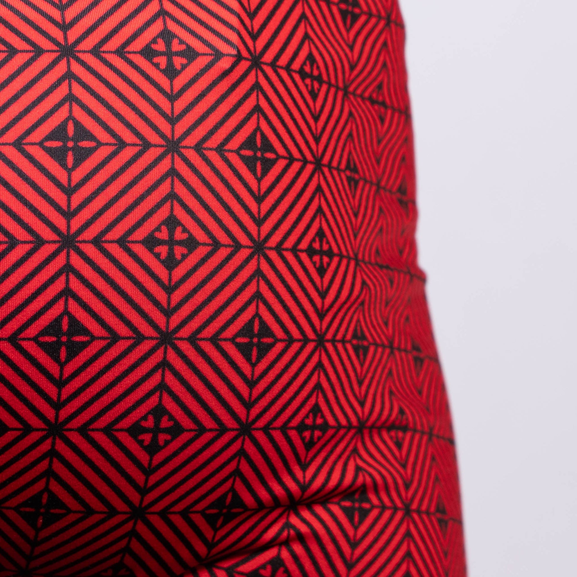 Red fabric of the Kaleidoscope sq cut trunk with a bold black geometric pattern of interlocking diamonds and cross motifs
