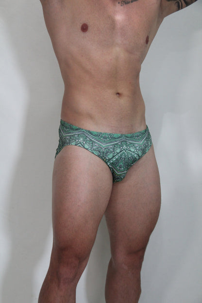 Green patterned kaleidoscope swim brief with intricate white geometric designs perfect for swimming and beachwear
