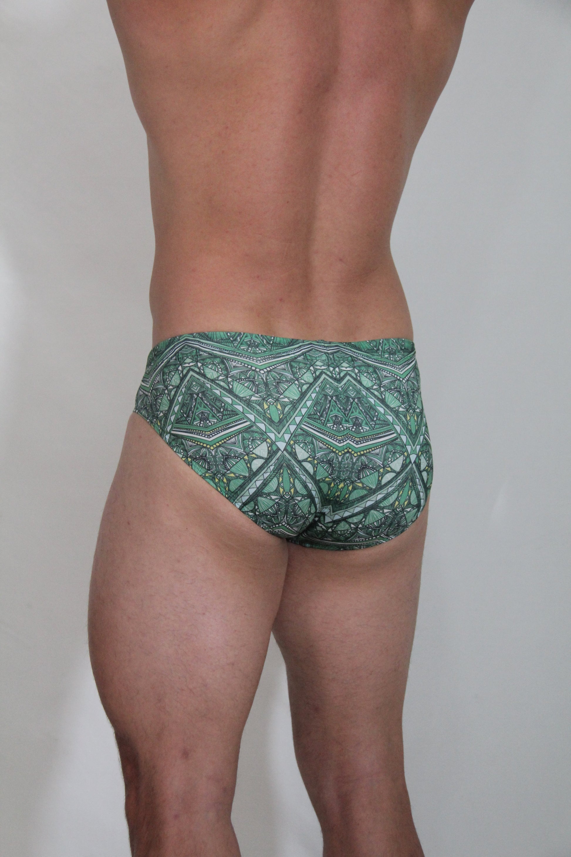 Green patterned kaleidoscope swim brief with intricate geometric and tribal-inspired designs for swimming