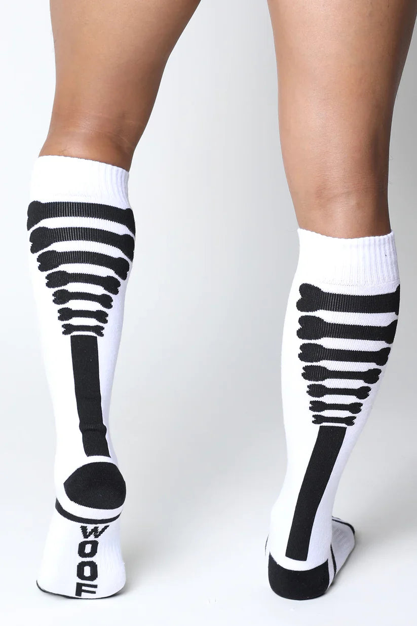 White knee high socks with black skeletal design and wool branding on the heel in kennel club bones style