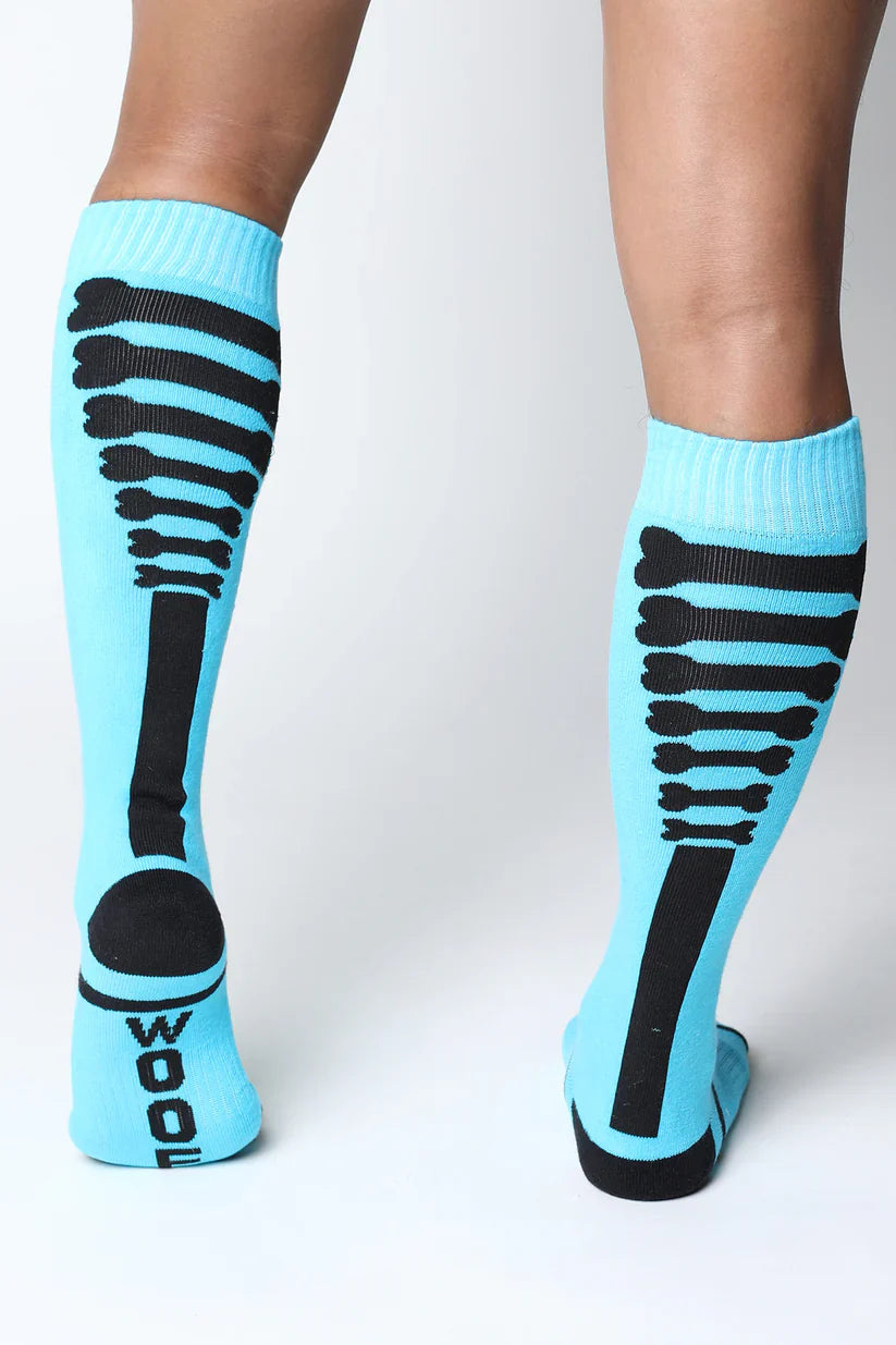Light blue kennel club bones knee high socks with black skeletal ribcage design and wool printed on the heel