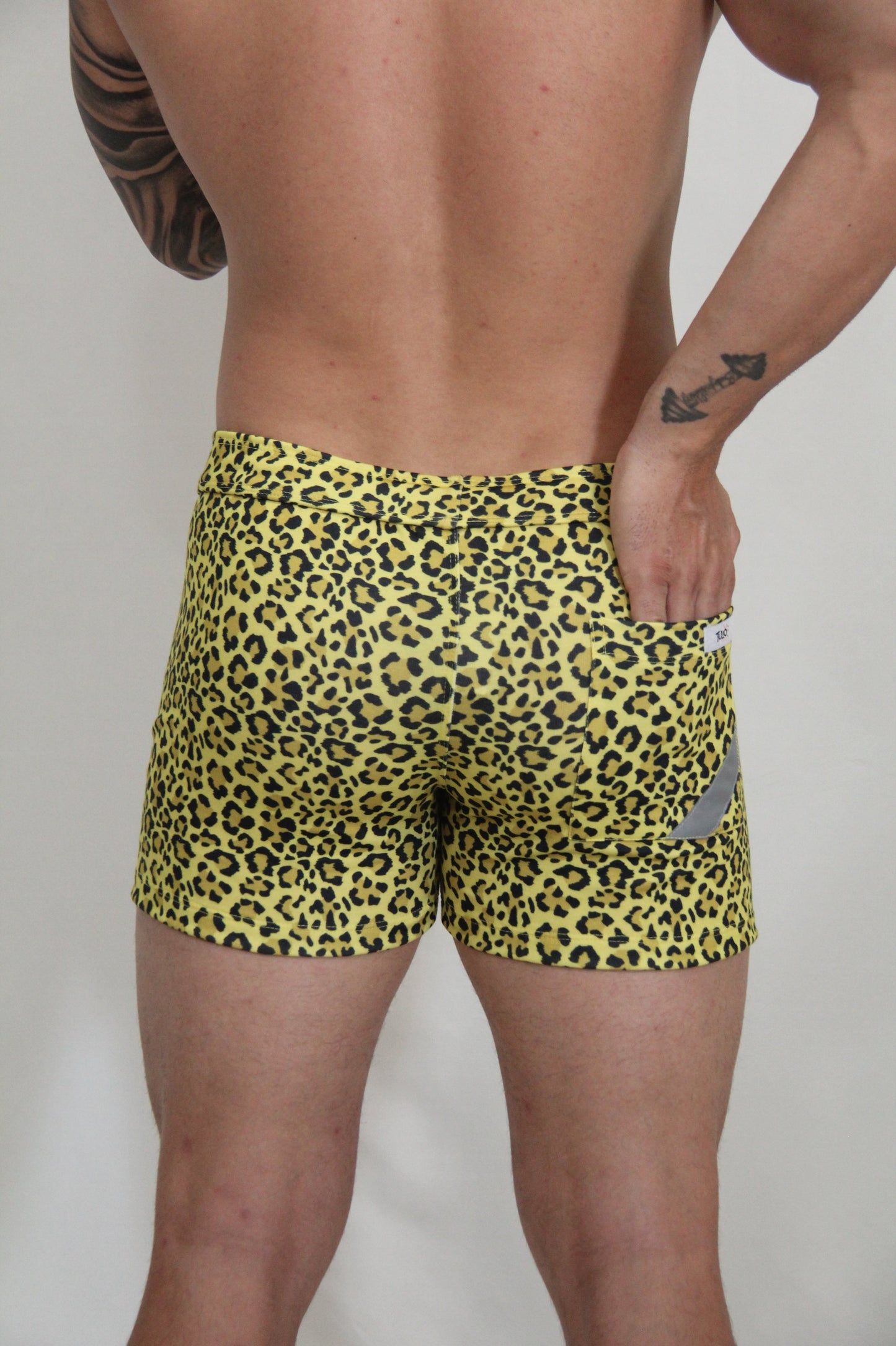 Yellow leopard fleece short with snug fit swim trunks and small gray reflective patch on the side