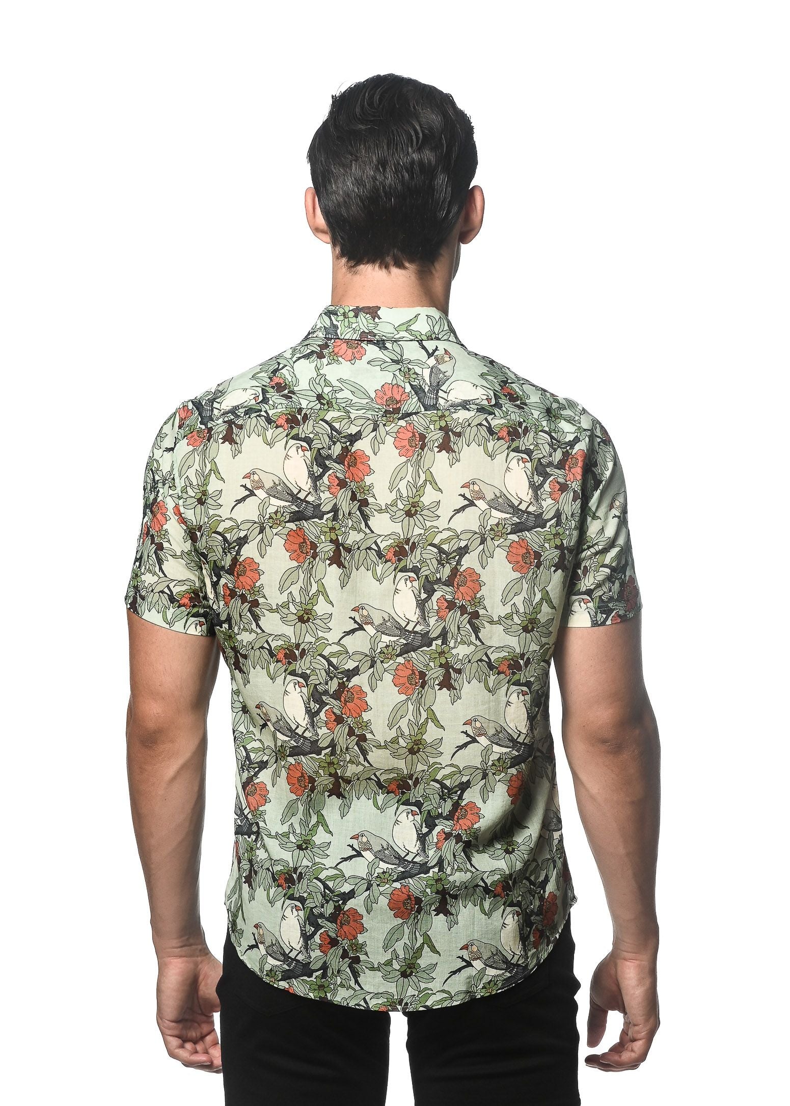 A man wearing a lightweight linen tencel short-sleeved shirt with a vibrant floral and bird pattern on off-white background