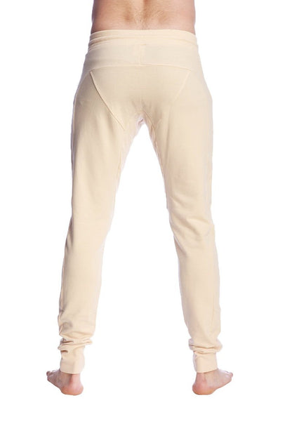 Cream-colored stretchy long cuffed jogger and yoga sweat pants in sand beige with tapered fit and rolled cuffs