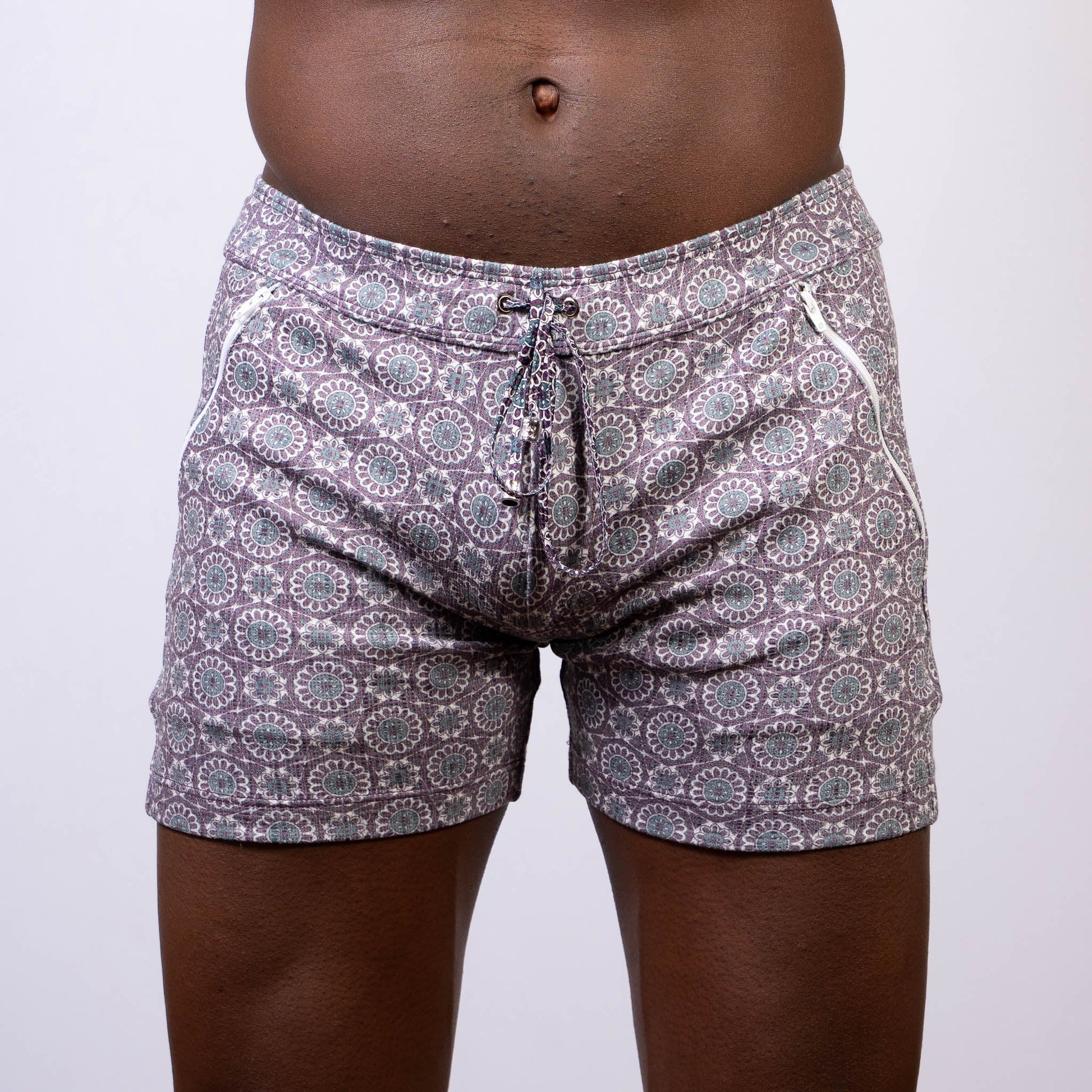 Gray and white mandala linen texture shorts with circular floral design and side zipper pockets for swimwear use