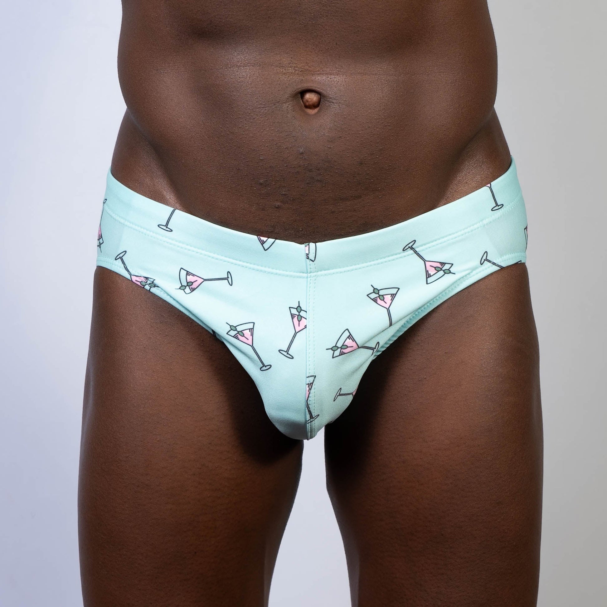 Mint green martini swim brief with playful pink martini glass pattern and black outlines perfect for swimming