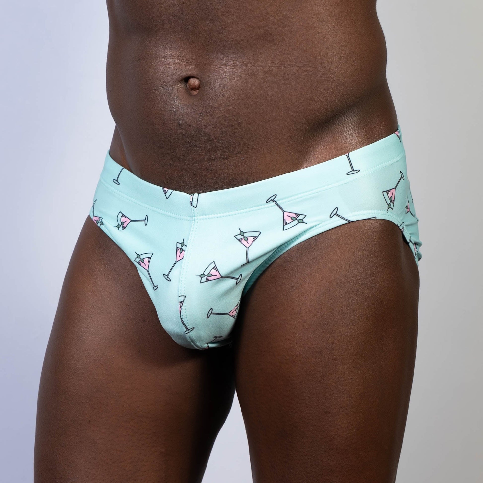 Mint green swim brief featuring playful pink martini glass pattern ideal for stylish beach and pool wear