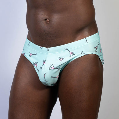 Mint green swim brief featuring playful pink martini glass pattern ideal for stylish beach and pool wear