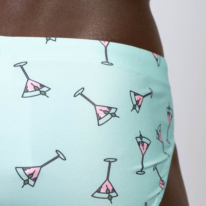 Mint green martini swim brief with pink martini glass pattern and olive garnishes in black outlines