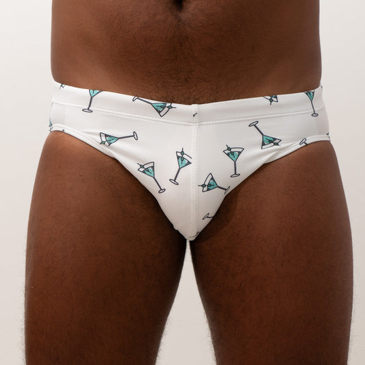 White swim brief with teal martini glass pattern and black outlines designed for stylish beachwear
