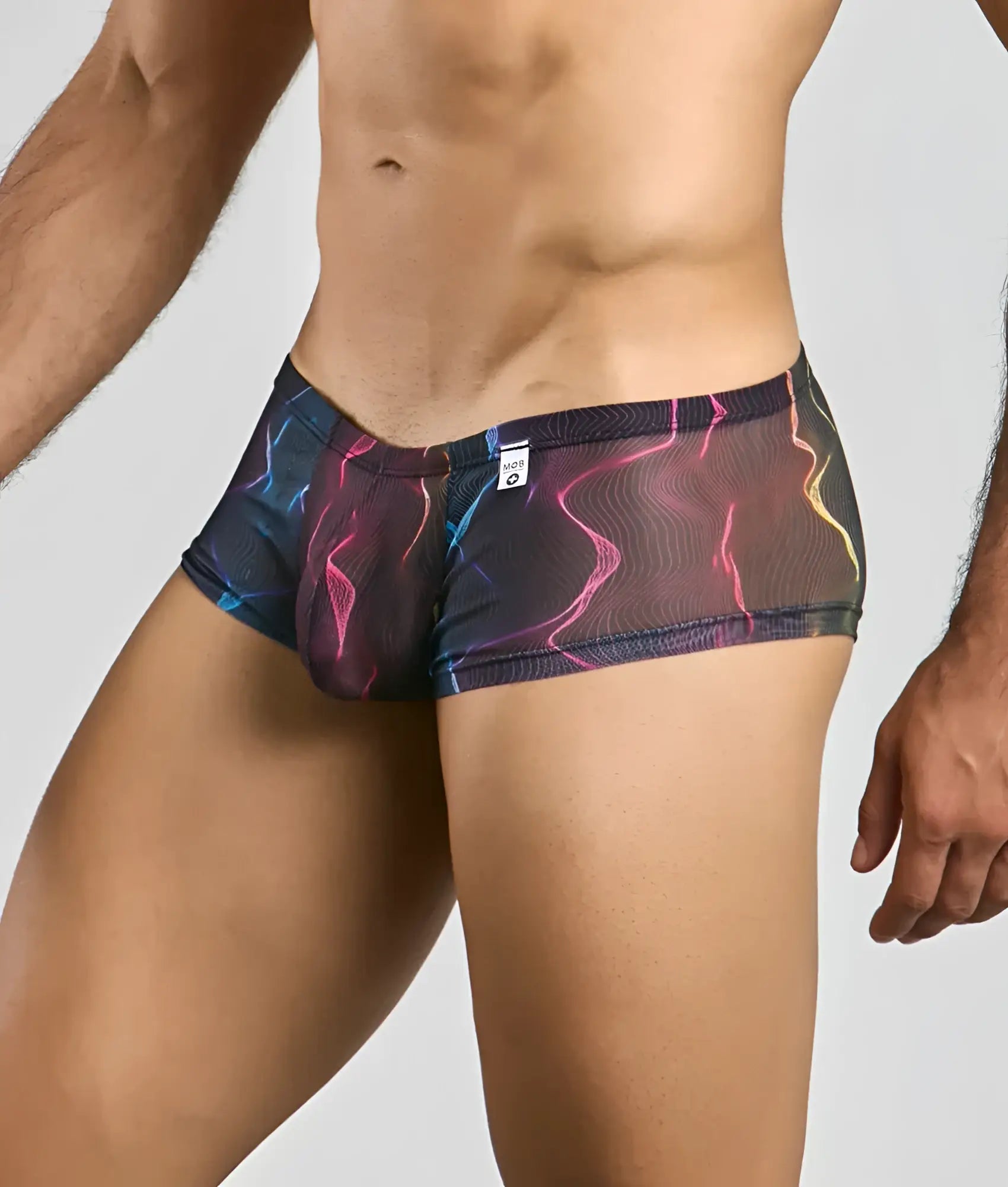 Mob men’s sexy sheer hip brief in vibrant electric pink blue and yellow lightning-patterned mesh on a dark base