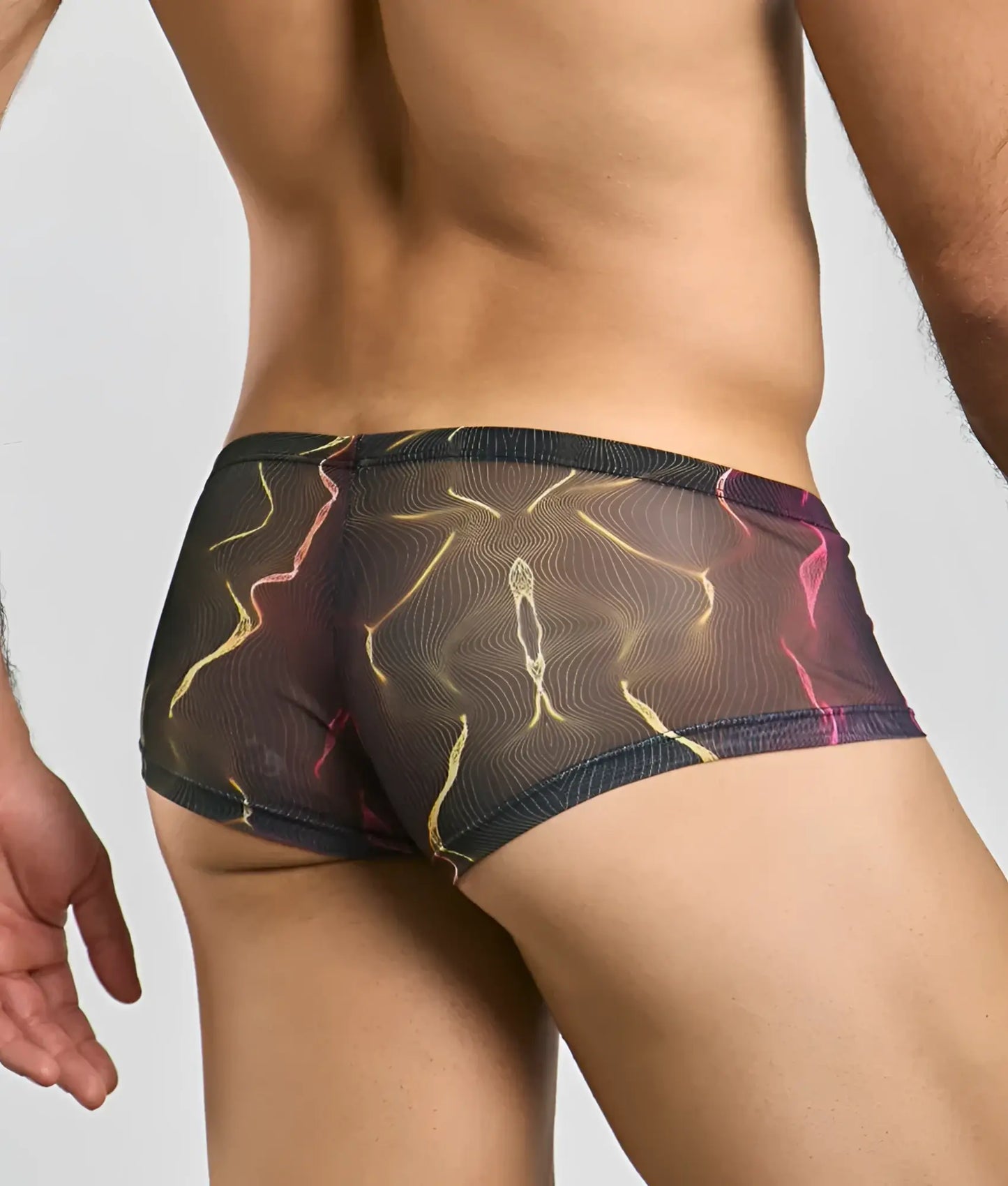 MOB men’s sexy sheer hip brief in black featuring a vibrant abstract pattern of glowing yellow and pink lines