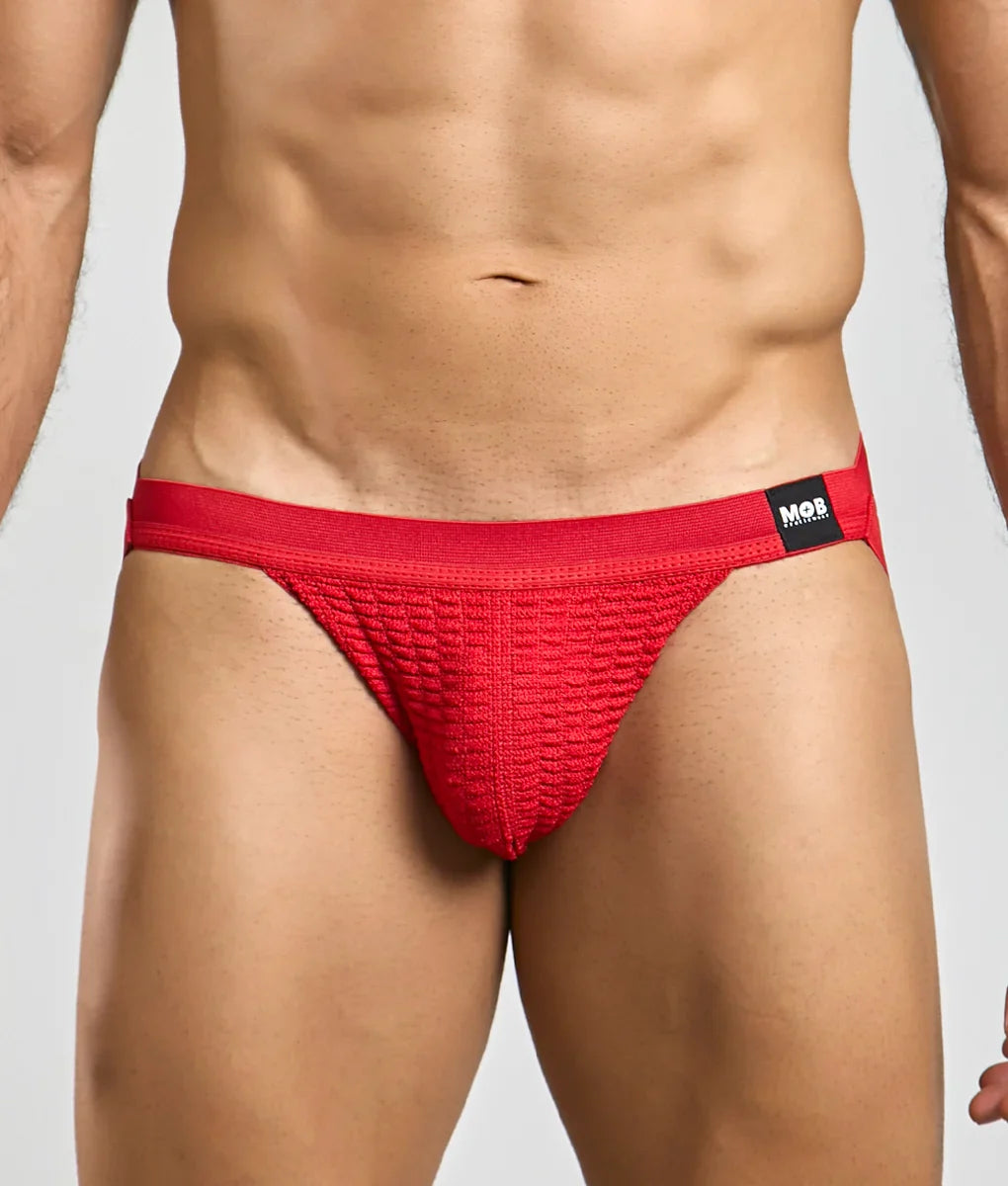 Red textured swim jockstrap briefs with a black mob brand tag on the waistband for swimwear use