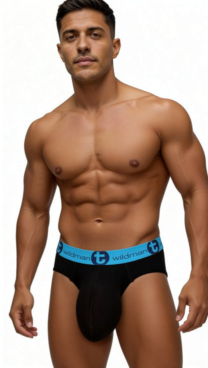 Muscular man wearing WildmanT black cotton briefs with a bright blue waistband featuring the brand logo.