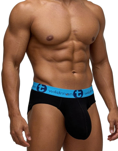 Muscular man wearing WildmanT black cotton briefs with a blue waistband featuring the logo, isolated on white.