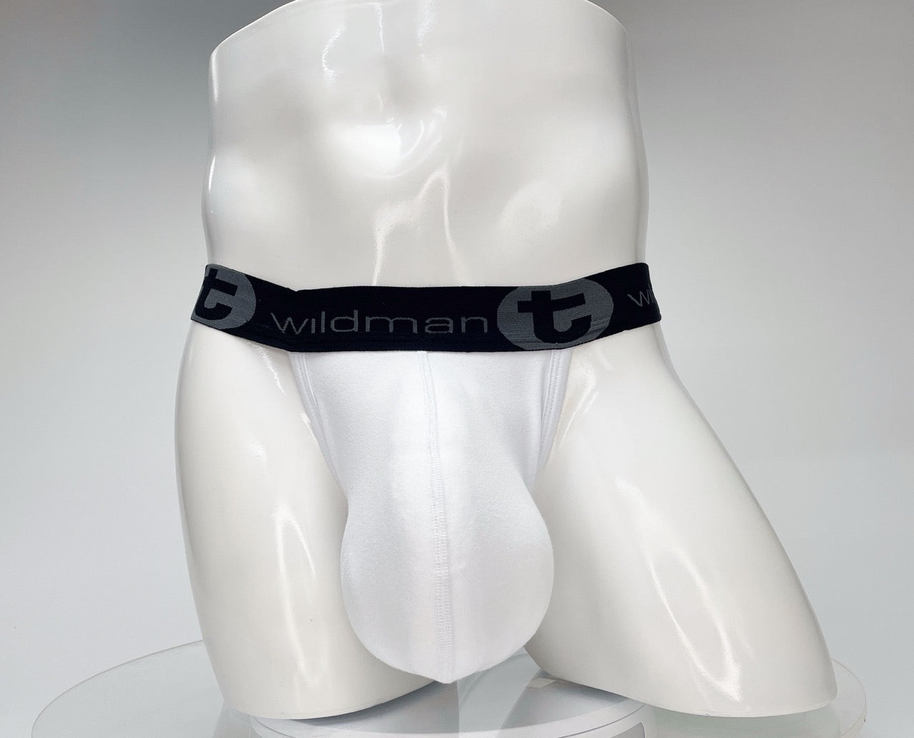White cotton jockstrap with a large, contoured pouch and a black waistband featuring "WildmanT" branding.