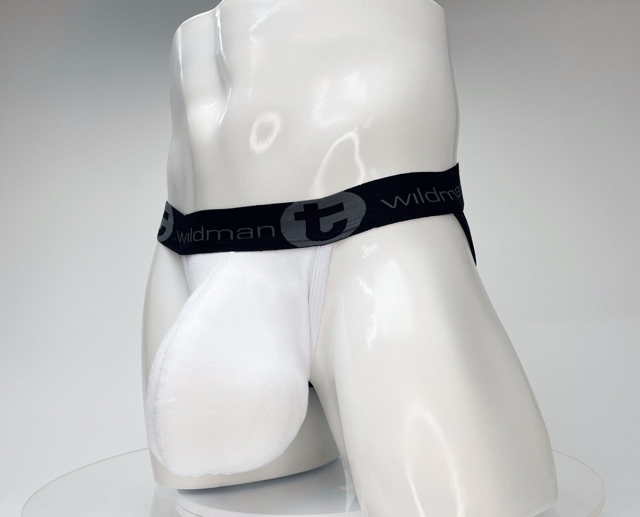 White WildmanT jockstrap with a large front pouch and a black branded waistband on a white mannequin.