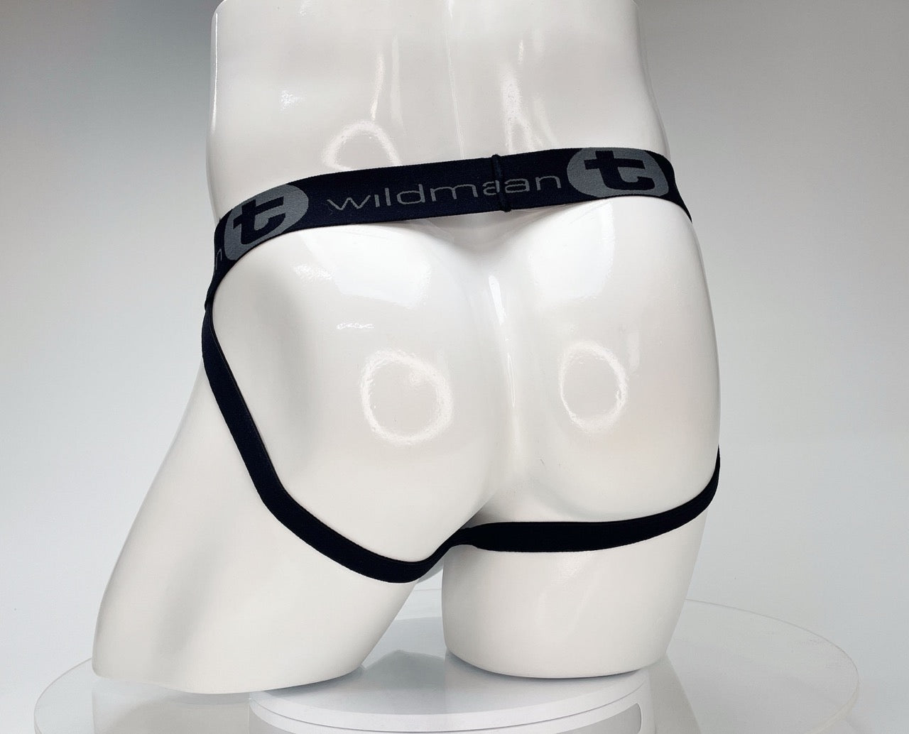 White WildmanT jockstrap on a mannequin, featuring a black branded waistband with the WildmanT logo.