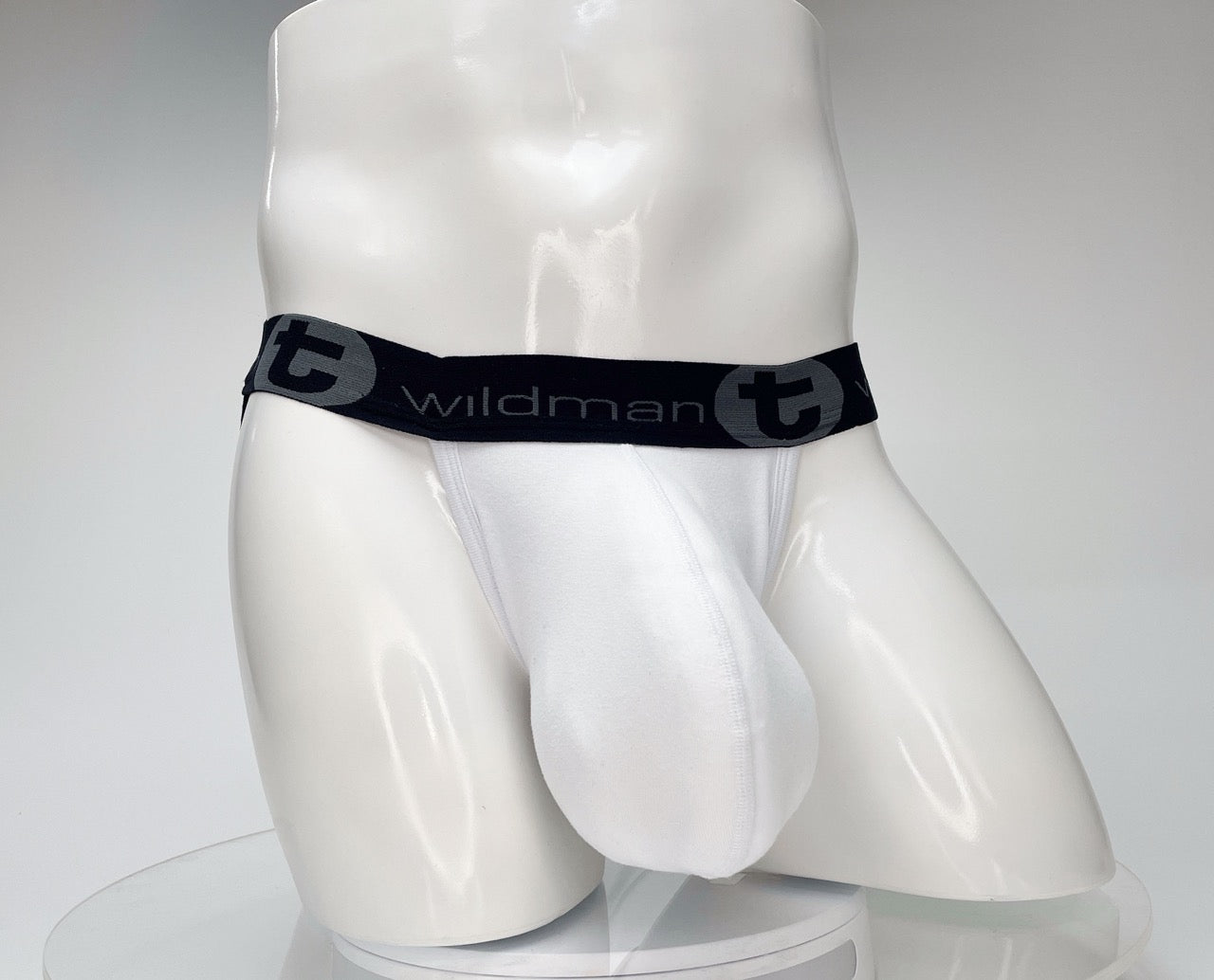 White WildmanT cotton jockstrap with a contoured front pouch and black elastic waistband featuring the brand logo.
