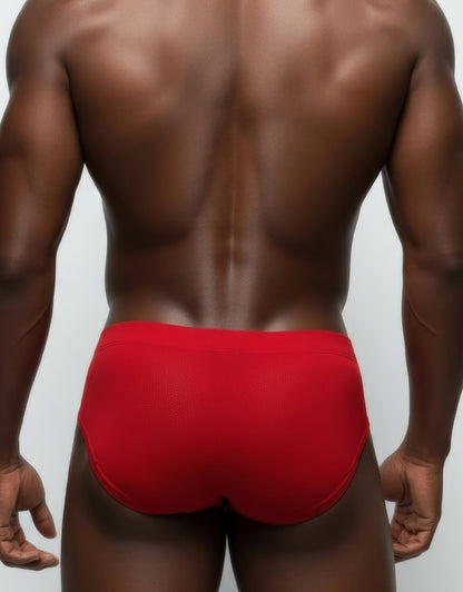 Back view of a man wearing red mesh briefs with a solid waistband.