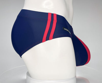 Navy blue swim brief with red side stripes and logo patch, shown from the side on a mannequin.